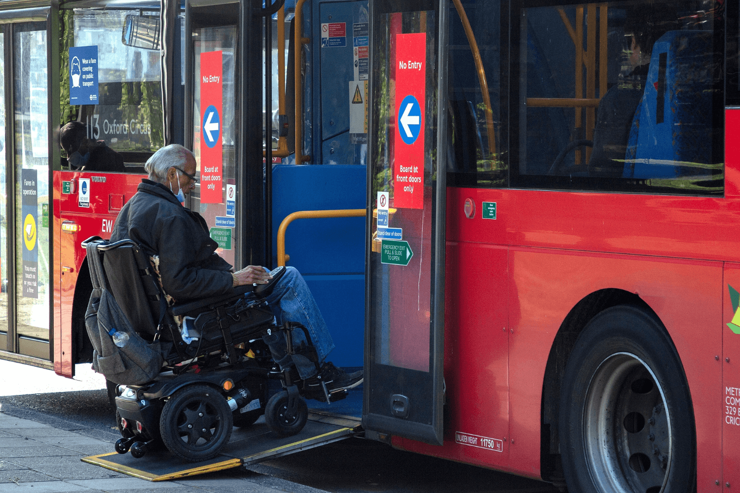Disabled individual entering bus on ramp